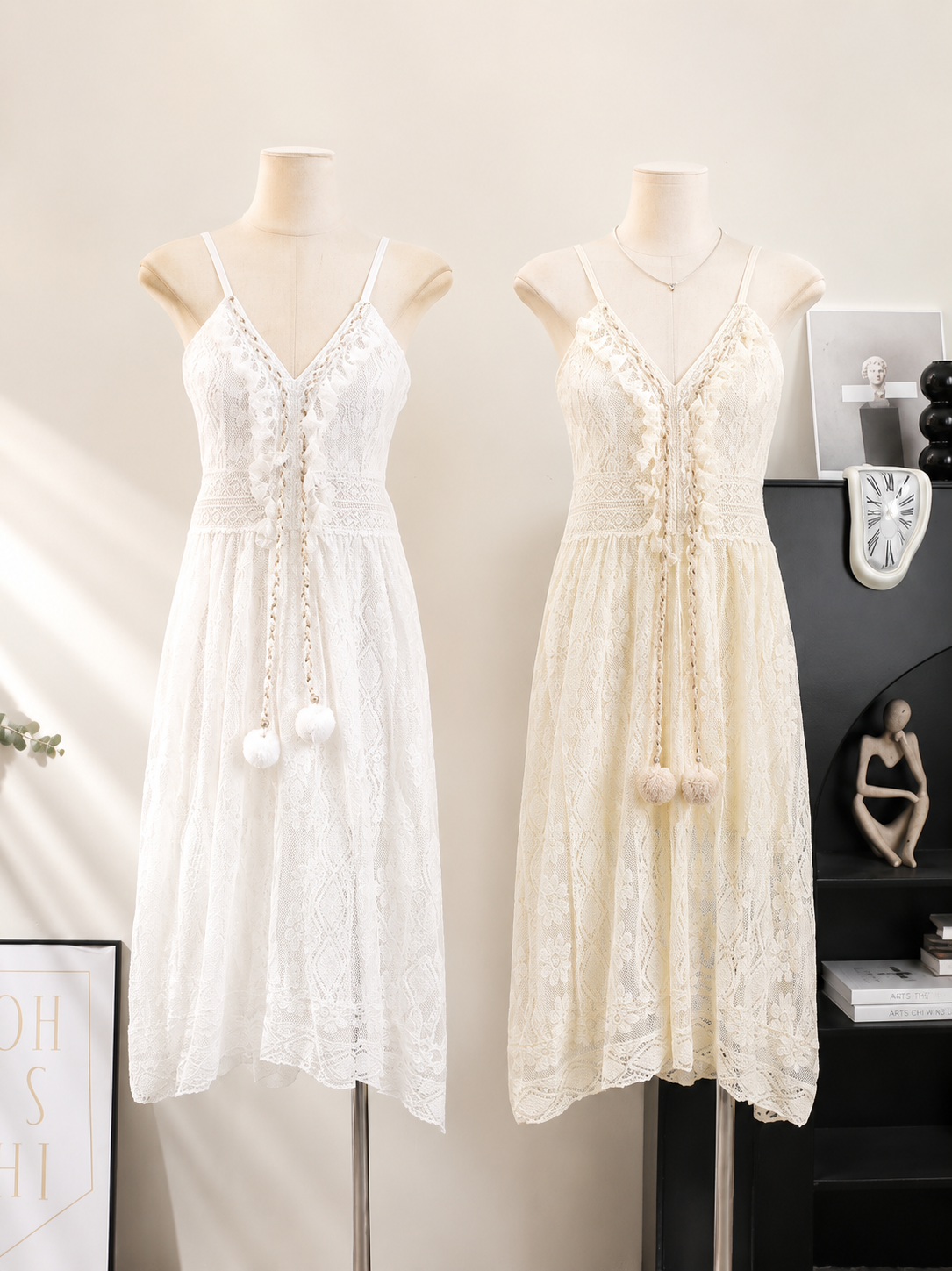 Two white lace dresses on mannequins against a neutral background